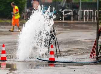 Road spurt water beside traffic cones — Water Management Near Me in NSW